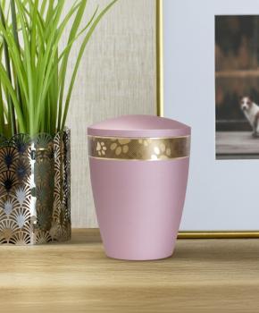 Elegant pet urn in soft matte pink with a golden accent ring, lovingly displayed in a home setting for a cherished remembrance of a beloved pet (dog/cat).